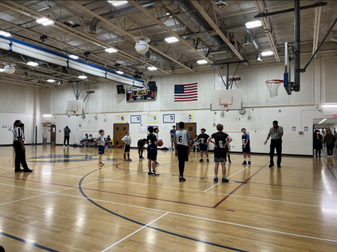 Coach Jack Solini alongside his team of fifth and sixth grade boys. Assisting in coaching is Hamza Alkalamchi and Pearson Leinbach.