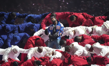 Along with the dancers wearing the colors of the american flags, there is another meaning to their colors. That being the colors of the Bloods and Crips street gangs whom Kendrick has been surrounded by growing up in Compton, California. Photo accredited to Timothy A. Clary/Getty Images.