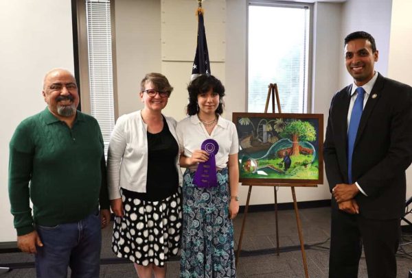 Elmira and her family with her art piece that was awarded. 
